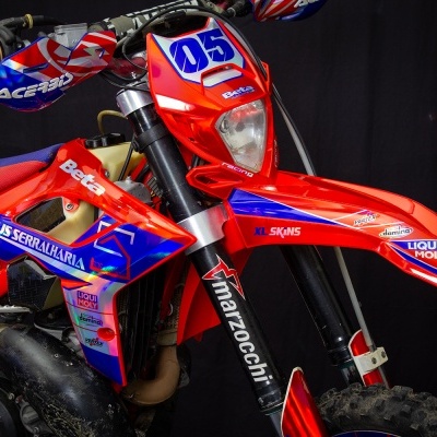 Motocicleta de competição vermelha e azul com autocolantes e número 05