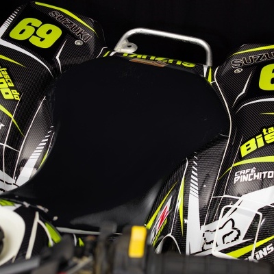 Motorizada Suzuki com gráficos pretos, brancos e amarelos, texto 69 e tasca do bispo