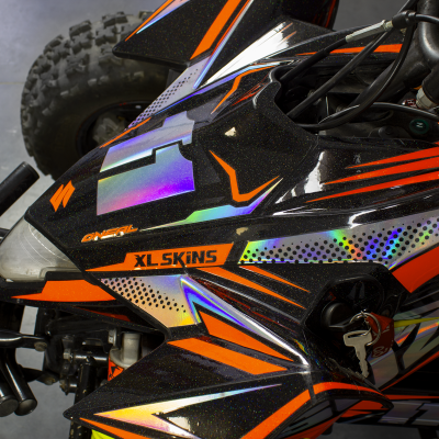 Veículo todo-o-terreno preto com detalhes gráficos laranja, roxo e verde e texto XL SKINS