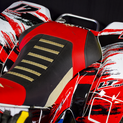 Assento de mota ATV vermelho, preto, bege e parte dianteira da mota com padrões e números