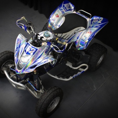 Quadriciclo azul e branco com números e detalhes Suzuki