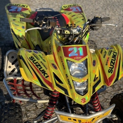 Quadriciclo amarelo com adesivos coloridos e o número 21