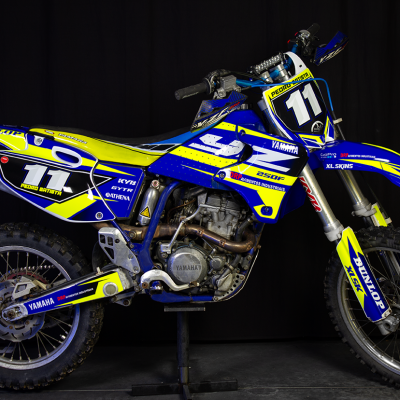 Motocross Yamaha azul e amarelo com número 11 em fundo preto