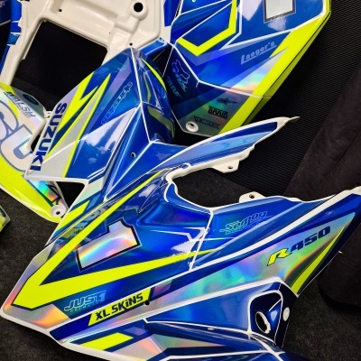 Peças de carenagem para mota Suzuki em plástico azul, amarelo e branco com texto impresso