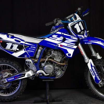 Moto de motocross Yamaha azul e branca número 11 em fundo preto