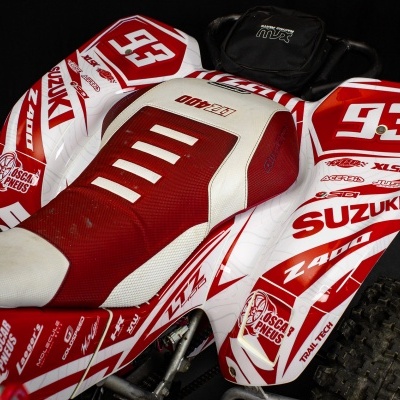 Quadriciclo vermelho e branco Suzuki com número 93 e logótipos visíveis