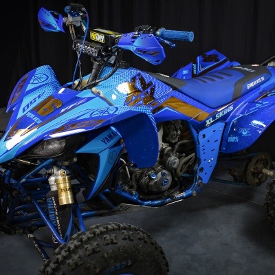 Quad azul com pneus grandes e detalhes pretos e dourados