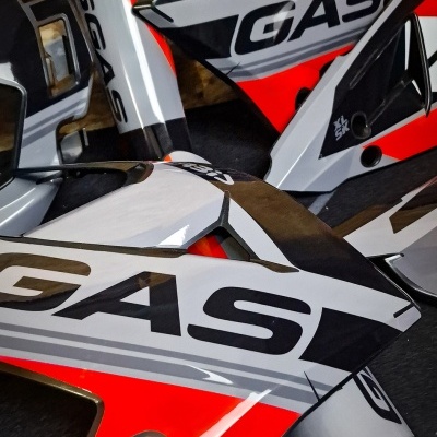Peças de carenagem de moto vermelhas, cinzentas, brancas e pretas com logotipo GASGAS