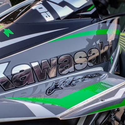 Depósito de combustível de motocicleta Kawasaki com design cinza, verde e preto e logotipo visível