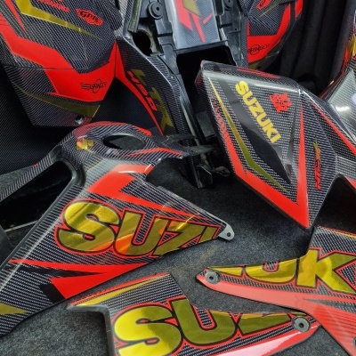 Carenagens para mota em padrão fibra de carbono com textos Suzuki, Red Bull e número 7.