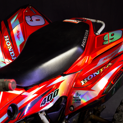 Triciclo Honda vermelho e preto com gráficos e números 9 e 6