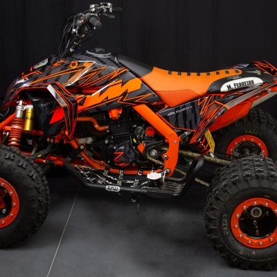 Quadriciclo laranja e preto com pneus grandes e estrutura robusta