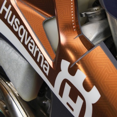 Motocicleta Husqvarna com pintura branca e laranja e logotipo visível