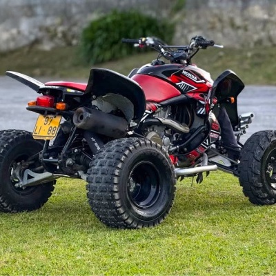 Quadriciclo vermelho e preto com pneus robustos e matrícula