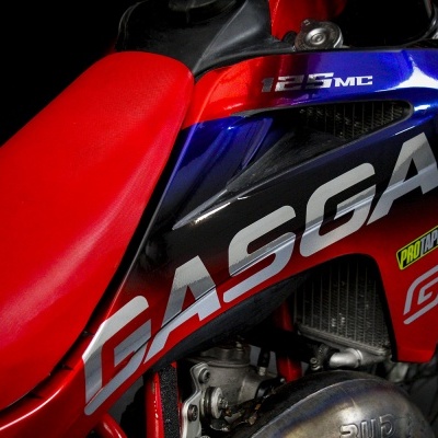 Motociclo vermelho com banco vermelho e textos GASGAS e 125 MC
