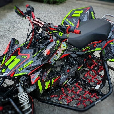 Quad preto com detalhes verdes, amarelos e vermelhos, números 11 e 21 visíveis