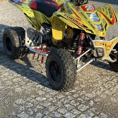 Quad Suzuki amarelo com número 21 e pneus para todo o terreno em calçada