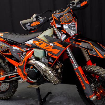 Motocross KTM laranja e preto com número #13 e pneus de terra