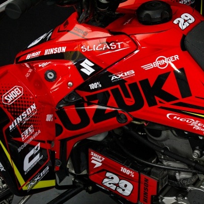 Motocicleta desportiva Suzuki vermelha com gráficos e logos de patrocinadores