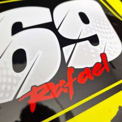 Placa ou adesivo amarelo e preto com os números 69 e nome Rafael em vermelho