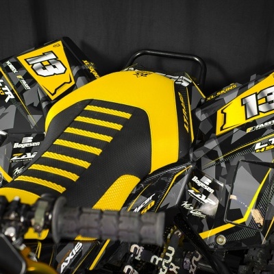 Moto de motocross preta e amarela com número 13 e vários autocolantes