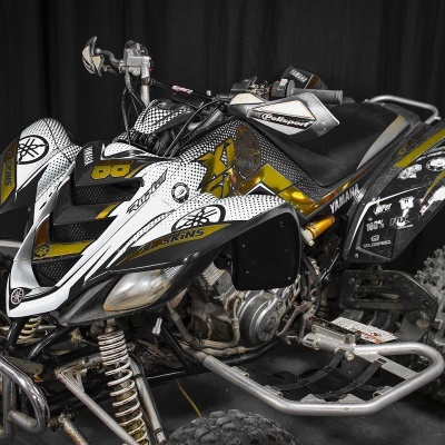 Quad Yamaha branco, preto e amarelo com números, grafismos e pneus grandes