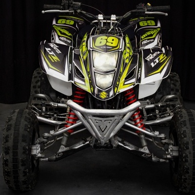 Quadriciclo todo-o-terreno com detalhes preto, branco e amarelo e suspensão vermelha