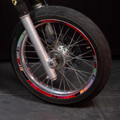 Roda de motocicleta com aro metálico prateado e texto YAMAHA em vermelho