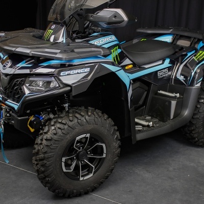 Veículo todo-o-terreno ATV CFORCE 850 preto, azul e verde, com pneus largos e faróis dianteiros.