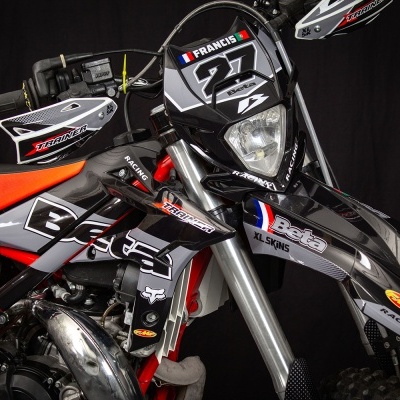 Motocross Beta preta e laranja com etiquetas TRAINER, Beta, FRANCIS 27 e bandeiras França e Portugal