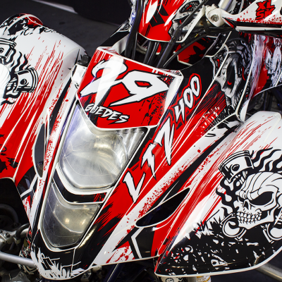 Quadriciclo desportivo vermelho, branco e preto com desenhos de caveira e texto LTZ 400