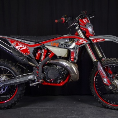 Motocross vermelho, cinzento e preto com número 27 e marcas UNI FILTROS e XL SKINS em fundo negro