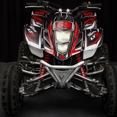 Quadriciclo preto, vermelho e branco visto de frente com o número 69 em destaque.