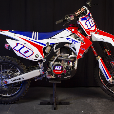 Motocross Honda CRF em branco, vermelho e azul com pneus Michelin e número 10