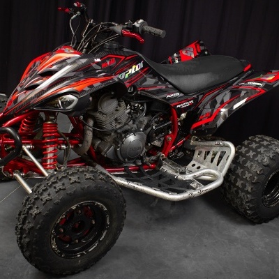 Quadriciclo todo-o-terreno vermelho e preto com pneus largos