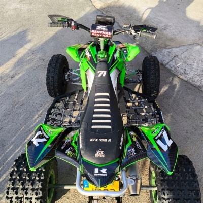 Quadriciclo verde e preto com pneus largos e número 71 visível no assento
