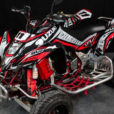 quadriciclo desportivo vermelho, branco e preto com pneus largos