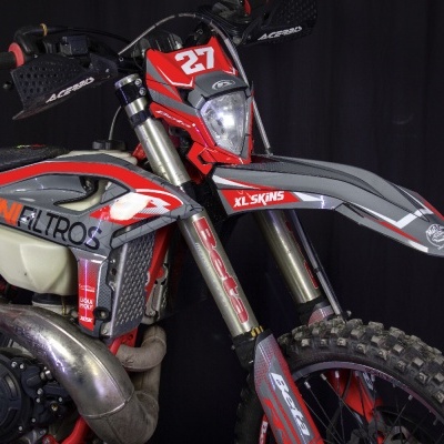 Motocross vermelha e cinzenta com número 27 e patrocínios