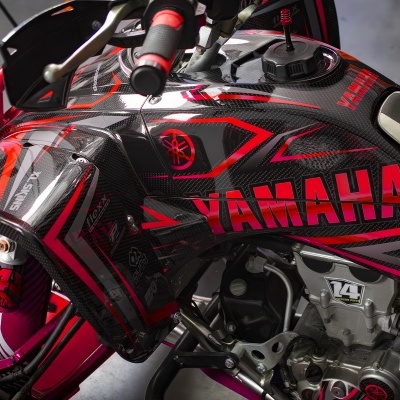 Tanque de moto Yamaha em fibra de carbono preta com logotipo vermelho e motores expostos