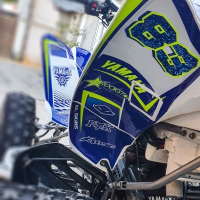 Quadriciclo Yamaha com gráficos azuis e amarelos, número 88 e marcas visíveis