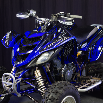 Quad Yamaha azul e preto com texto RACETECH e pneus de borracha em estúdio escuro