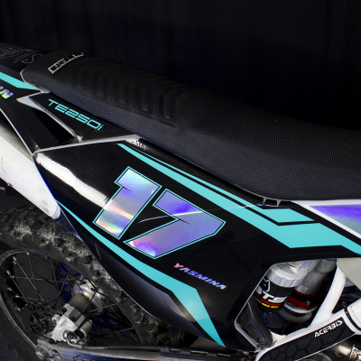 Parte traseira preta de mota de motocross com número 17, detalhes azuis e assento preto