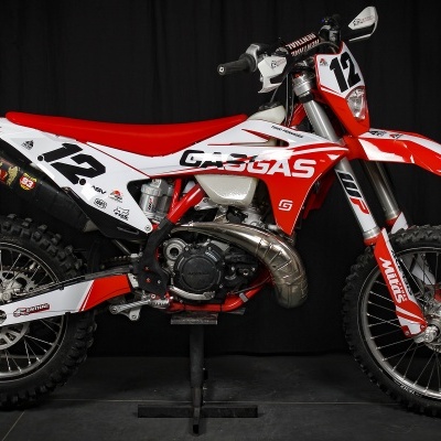 Motociclo off-road GASGAS vermelho e branco com números 12