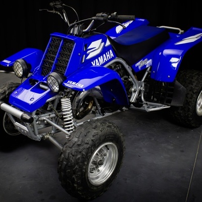 Quadriciclo azul Yamaha com pneus grossos e faróis