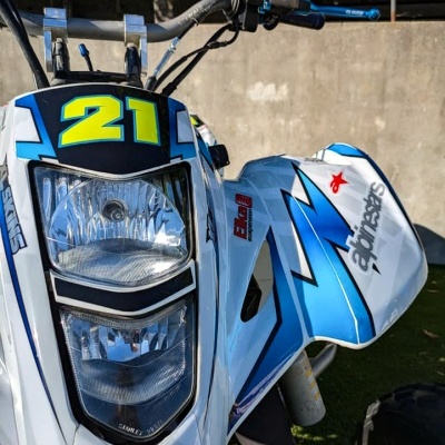 Quad branco com detalhes em azul e preto, número 21 e texto alpinestars.