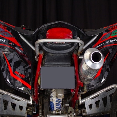 Quad todo-o-terreno vermelho e preto com escapamento metálico e pneus largos