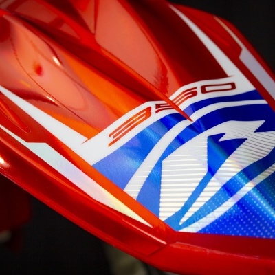 Peça vermelha brilhante com gráficos azuis e brancos e texto '350'