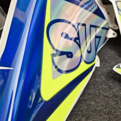 Carenagem de mota azul e amarelo com logotipo parcial SUZ