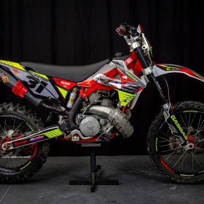 Motocross vermelho e amarelo com número 31 em estúdio