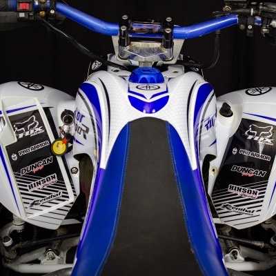 Quad ATV branco e azul com guiador azul e tampas laterais com autocolantes pretos e brancos